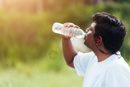 黑人在户外街头健康公园跑后喝瓶水健康锻炼概念图片