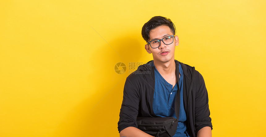 亚洲英俊年轻男子戴眼镜或的肖像黄背景短片室有复制空间时装男美貌概念图片