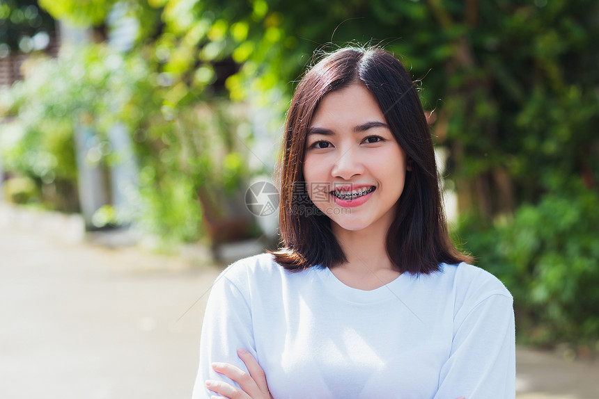 亚洲少女的肖像美丽年轻女子微笑牙齿套在上户外笑医学和牙概念图片