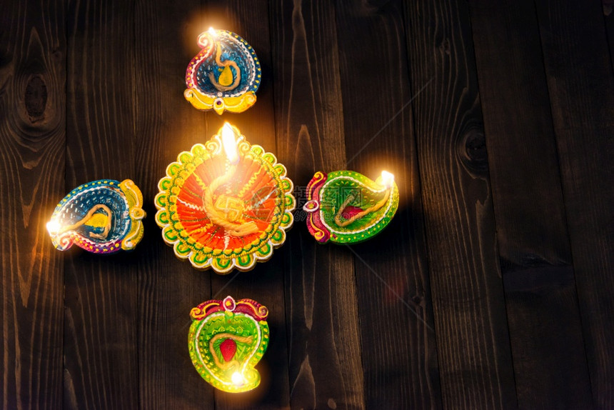 上方的天观粘土点燃了对Diya或油灯的火光黑木背景拍摄的影棚印度兰焦利的装饰庆祝快乐的迪瓦利或节的概念图片
