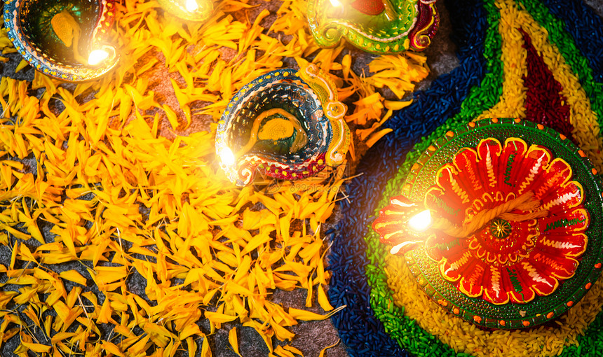 紧的粘土点燃了已经对Diya或油灯的火焰鲜花放在混凝土背景上印度兰焦利教的装饰迪瓦利印度节庆祝活动快乐或迪瓦利印度节的概念图片