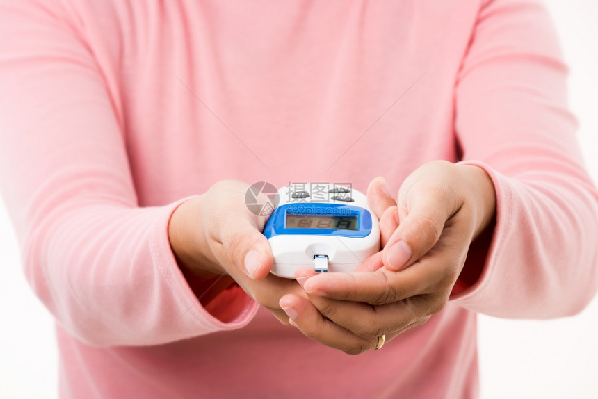 测量葡萄糖试水平用血压计检查手指的妇女图片