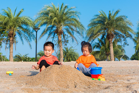 两个孩子在户外热带海滩玩沙子图片