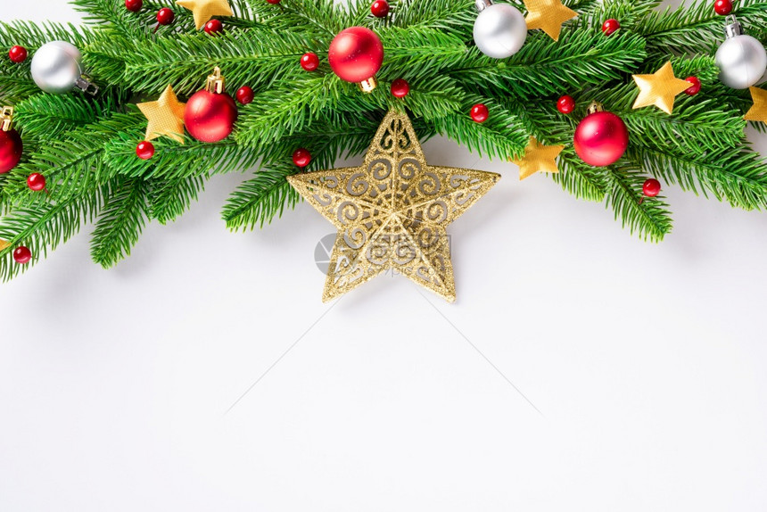 圣诞花环冷杉树枝装饰球和五彩纸屑星星俯瞰节日圣诞节装饰和白色背景上孤立的装饰品新年贺卡的概念图片