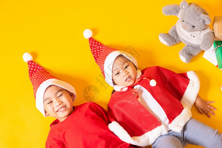 亚洲小可爱男孩女笑亚洲小可爱男孩女双兄弟男穿着红圣诞老人帽子节或新年快乐的概念背景图片