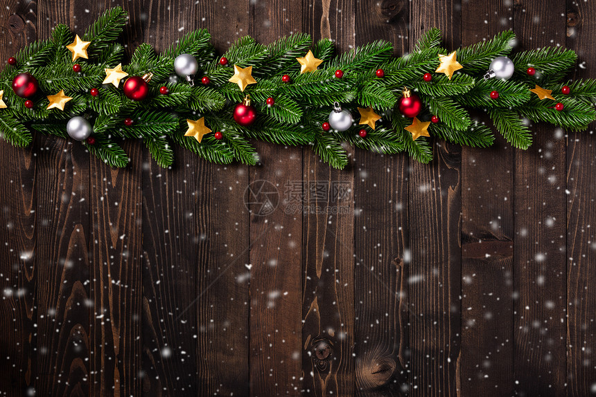 圣诞假日园林边界树壁枝的顶端景色以及Xmas恒星在黑色木背景上带有复制空间的装饰泡图片