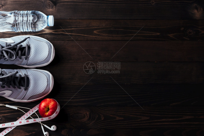 彩色运动鞋耳机黑木桌底的苹果和水瓶健身GYM康锻炼图片