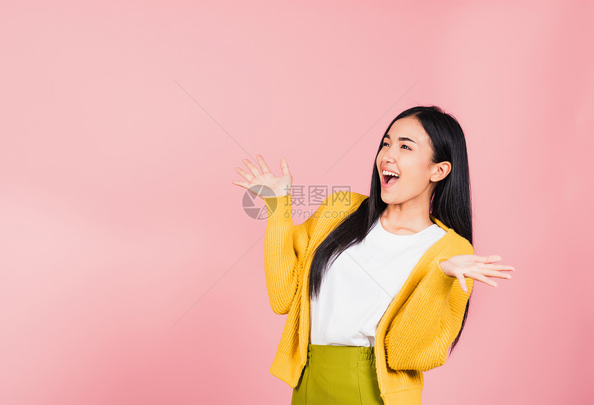 快乐的亚洲肖像美丽可爱的年轻女子站在胜利中惊异的兴奋尖叫张着嘴举起手工作室拍摄孤立的粉红背景泰国女哇与复制空间图片