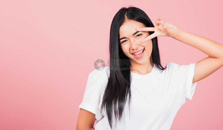 亚洲快乐的肖像亚洲美丽可爱的年轻少女笑着站手指在看摄影棚时图片