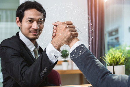 商业伙伴利用全球网络概念在办公室握手图片