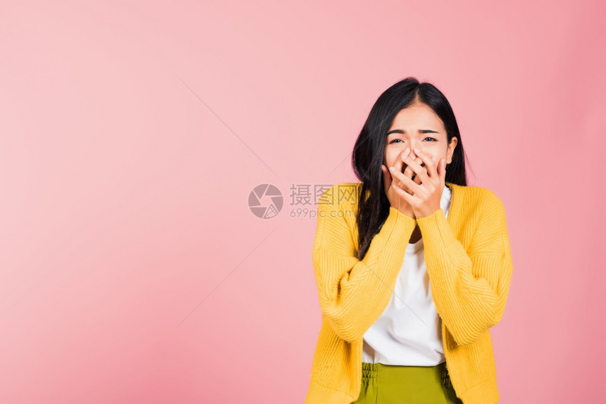 亚洲肖像美丽可爱的年轻女站立惊异吓的嘴盖着手掌的套看着摄影机棚拍图片