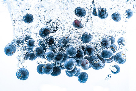 新鲜蓝莓在白底水中坠落果在清中喷洒抗氧化剂健康概念图片