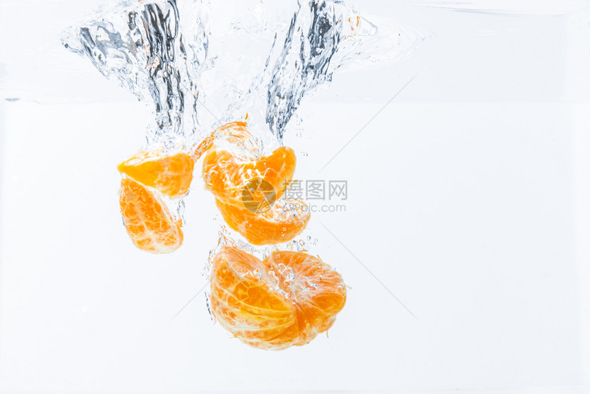 将孤立的橙子落到水中在白底孤立的水中切橙子果健康概念在白底孤立的水中切橙子果图片