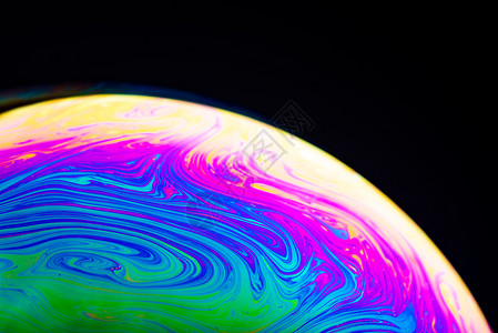 黑暗背景的彩虹肥皂泡香色表面的接近从反映光线的肥皂泡沫中总结的背景图片