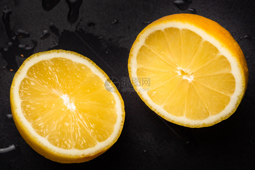 朱莉黄色柠檬被切成半块黑色背景被隔绝图片