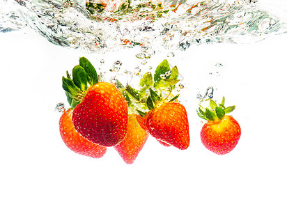 草莓坠入水中导致周围的泡沫健康食品概念白色背景草莓坠入水中造成周围的泡沫健康食品概念背景图片