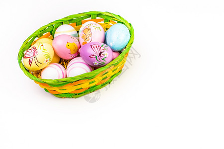 白色背景柳条篮里装满了复活节鸡蛋图片
