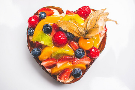 心形水果海绵蛋糕餐桌上白背景的水果塔特健康甜食背景心形水果海绵蛋糕2图片