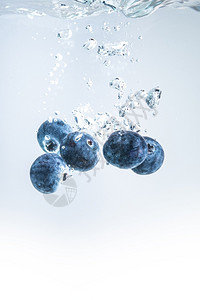 有机蓝莓沉入水中空气泡是白色的有机蓝莓沉入清澈的水中背景图片