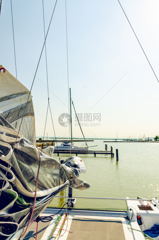 奥地利内西德列尔斯湖上的Catamaran船日落前清空平静的水与日落后空间相仿奥地利内西德列尔斯湖上的Catamaran船图片