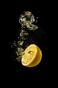 新鲜黄色柠檬一半在黑背景的喷水中有很多气泡刷新概念图片