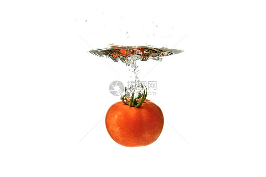 白色背景水中新鲜红番茄喷洒在白背景水中健康食品概念图片