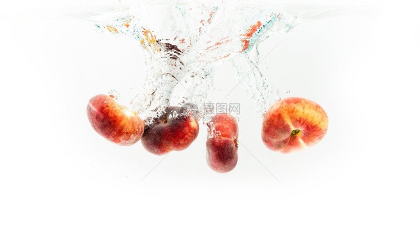 一群甜圈桃子在白色上被孤立掉入水中果与气泡一起沉入水晶清澈的中一群甜圈桃子在白色上被孤立喷入水中图片