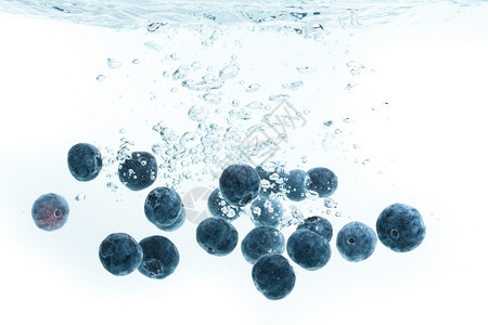 蓝莓沉入水中空气泡为白色背景蓝莓沉入白色背景的水中背景图片