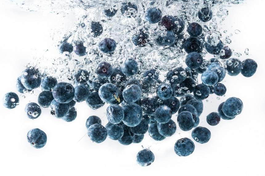 蓝莓沉入水中空气泡为白色背景蓝莓沉入白色背景的水中图片