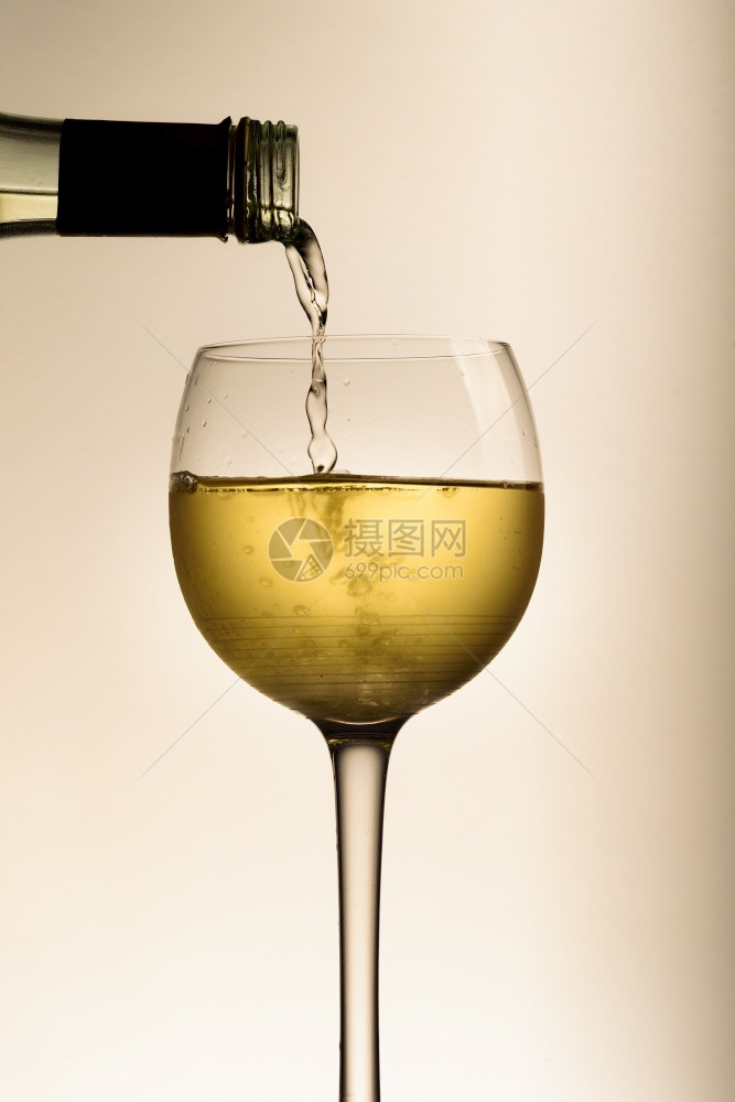 将白酒从瓶子倒入玻璃杯图片