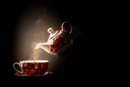 将蒸茶从悬浮的瓷壶倒入心脏设计杯中图片