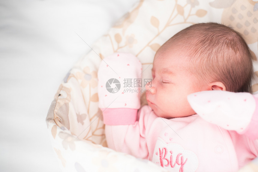 熟睡的新生婴儿可爱的小女孩4天大可爱的躺在一边戴着手套没有皮肤修饰复制空间在左边熟睡的新生婴儿可爱的小女孩4天大可爱的躺在一边戴图片