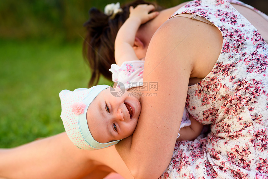 妈妈抱着女婴对着镜头逗她笑图片