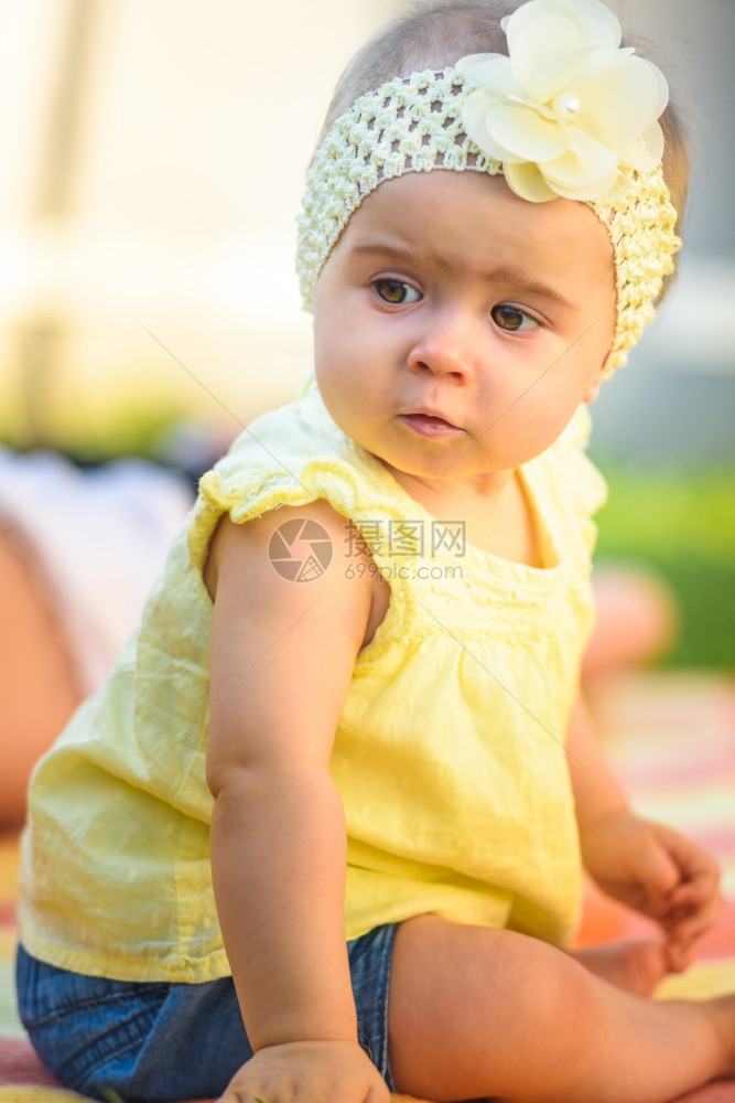 8个月大的婴儿户外活动发展概念黄色乐队的可爱女婴肖像和阳光明媚的后院着装图片