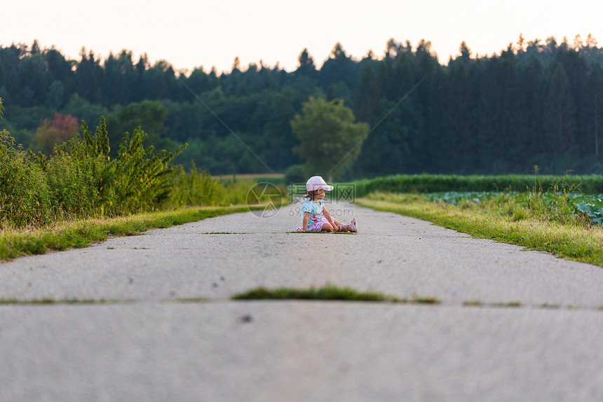 婴儿坐在农村道路的中间图片