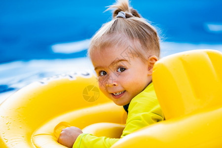 游泳池中的孩子黄色充气腰部婴儿夏季游泳池中的孩子黄充气腰部婴儿图片