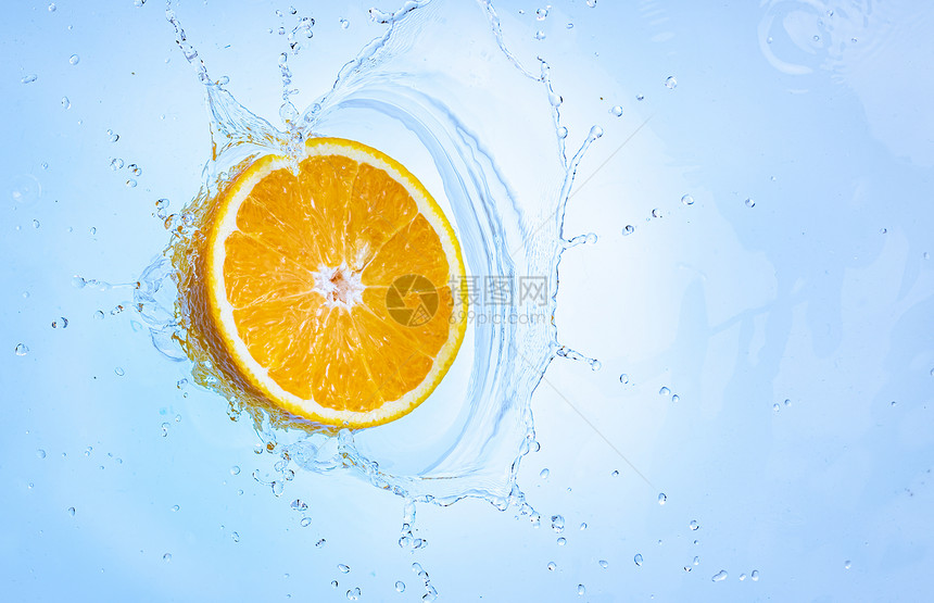 新鲜成熟的半个橙子喷洒到清水中以浅蓝色背景隔绝健康食品概念新鲜成熟的半个橙子水果喷洒到清中图片