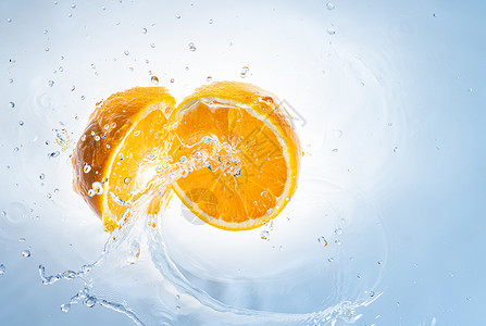 橙子水果在浅蓝色背景中被隔离健康食品概念橙子水果在清中被喷出两半图片