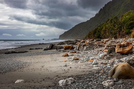 暴风天气逼近新西兰一个岩石堆积沙滩图片