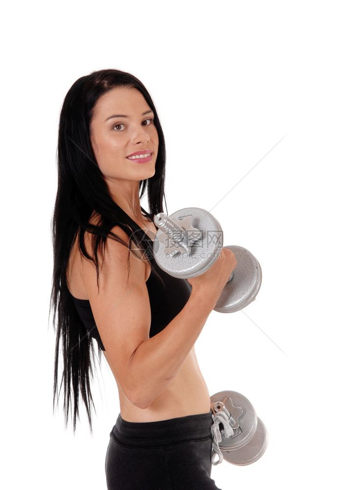 一个美的年轻女子长的黑头发站在侧面与两个哑铃锻炼力量孤立的白色背景图片