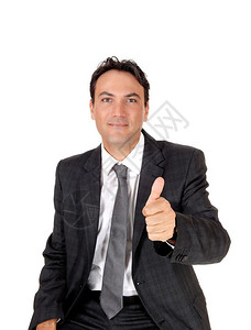 一个年轻的商人坐在黑暗灰色西装和领带展示他的赞同与振动孤立白色背景图片