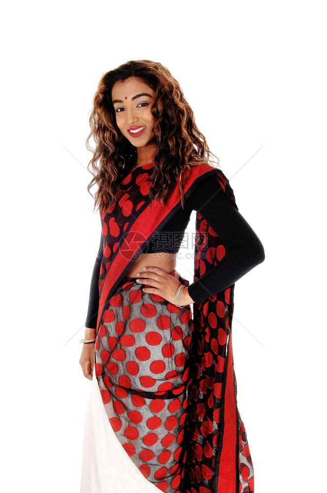 一个美丽的东印度青少年站在多彩的印度沙里一只手在她的臀部和长卷发上图片