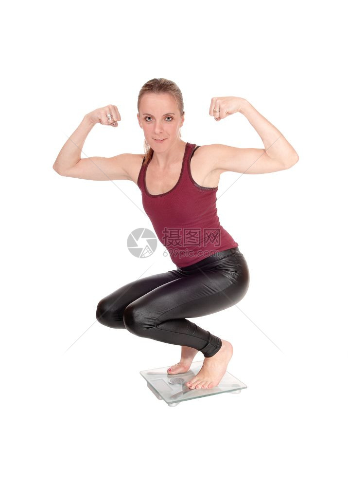 身穿黑皮裤的年轻瘦女人身穿黑皮裤手抱伸缩的肌肉图片