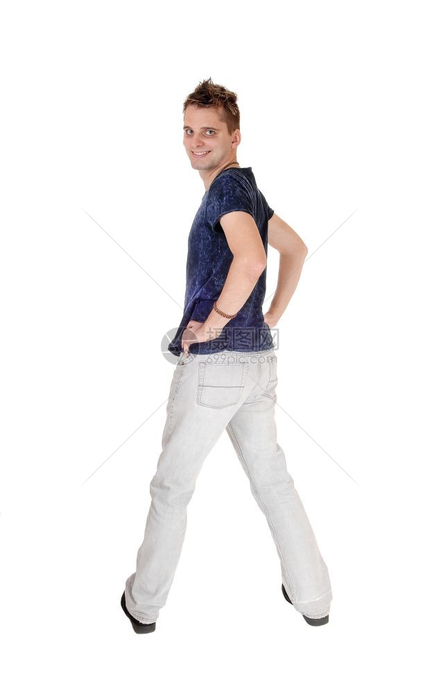 一个身穿浅灰色牛仔裤高的年轻男子站在背对着手伸在臀部肩膀上图片