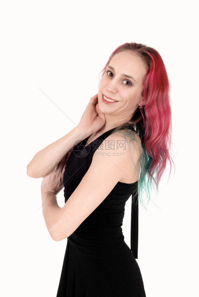 一个可爱的年轻姑娘穿着黑色裙子红长头发的微笑着与白种背景隔绝图片