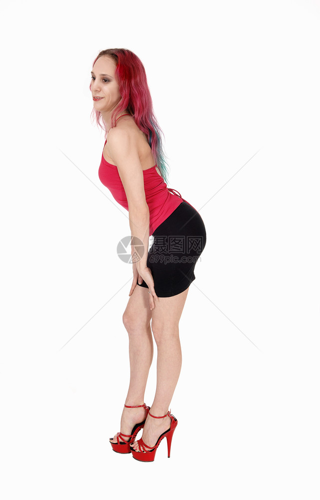 一个可爱的年轻女人站在黑色裙子和红上衣头发微笑与白背景隔绝图片