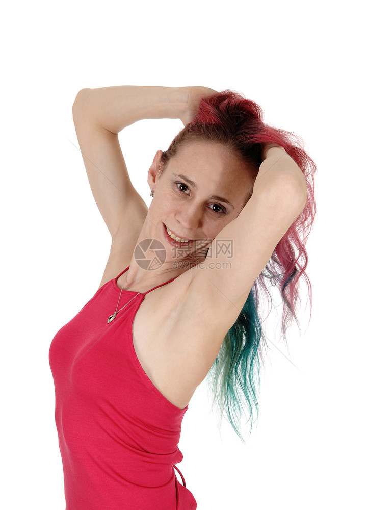 一个可爱的年轻女子站在红色的顶手在她红头发微笑腰上与白背景隔离图片