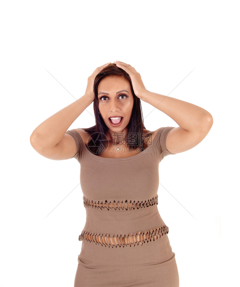 一位美丽的年轻瘦女人穿着棕色短裙双手戴在头上吓人与白背景隔绝图片