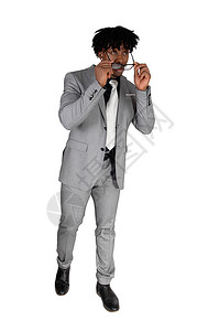 一个英俊的非裔美国人穿着浅灰色西装戴上太阳镜和走路图片