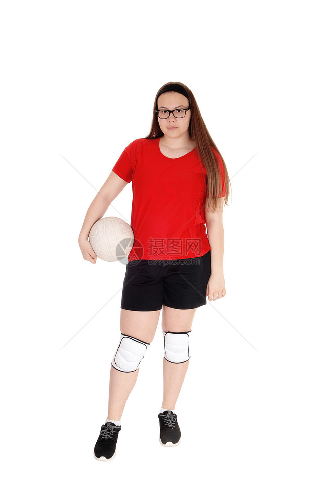 一个穿着制服的年轻少女手握着她的排球站在工作室里因白背景而孤立无援图片